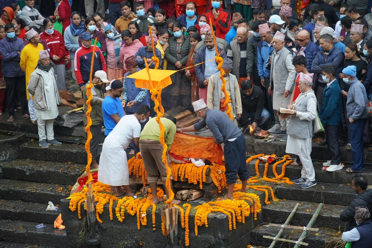 People gather for a funeral ceremony by the river.